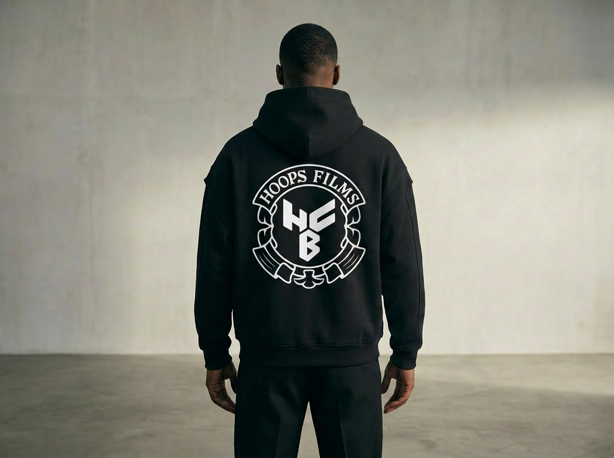 Person wearing a black hoodie with 'Troops Films' logo on the back in a neutral setting